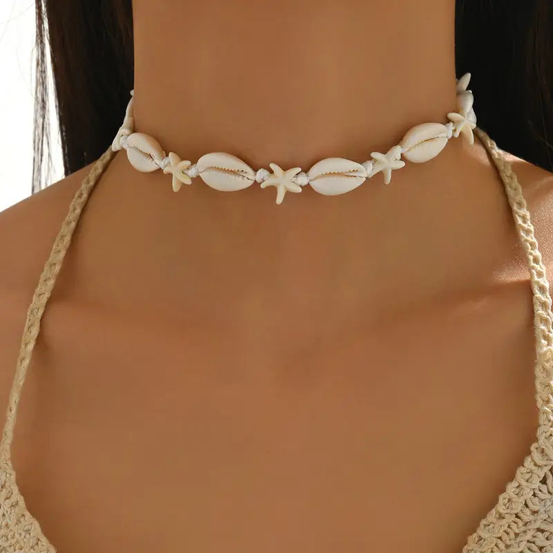 Shell choker necklace worn by a model with a blurred background