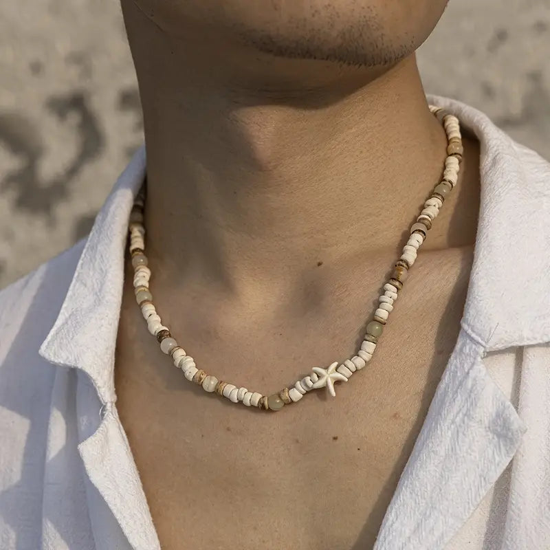 Person wearing a beaded necklace with a starfish charm against a neutral background