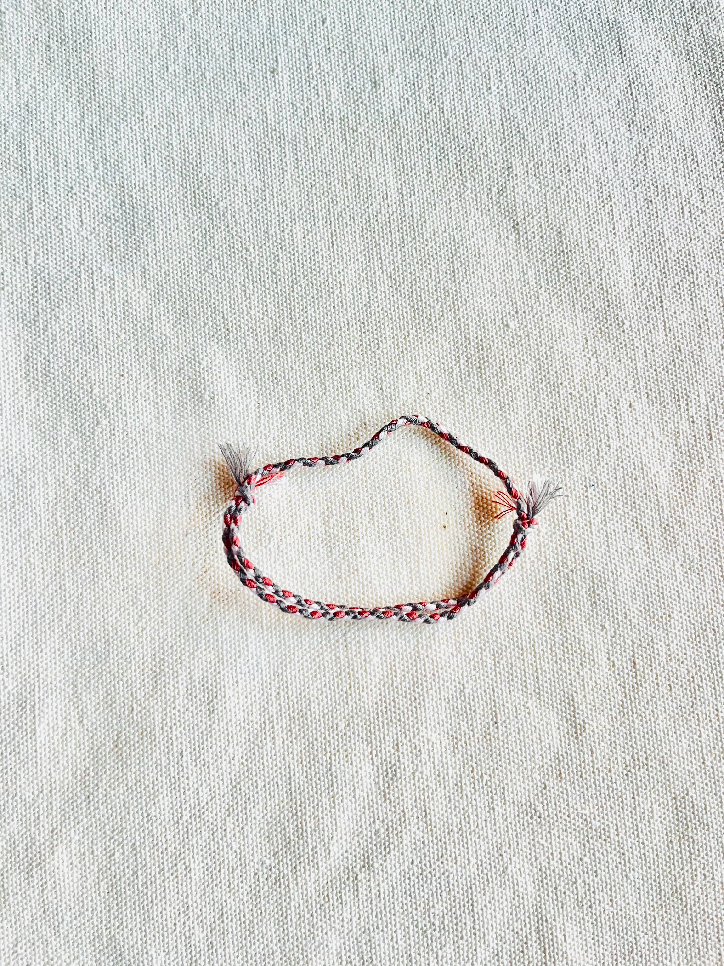 Braided bracelet on a textured beige surface