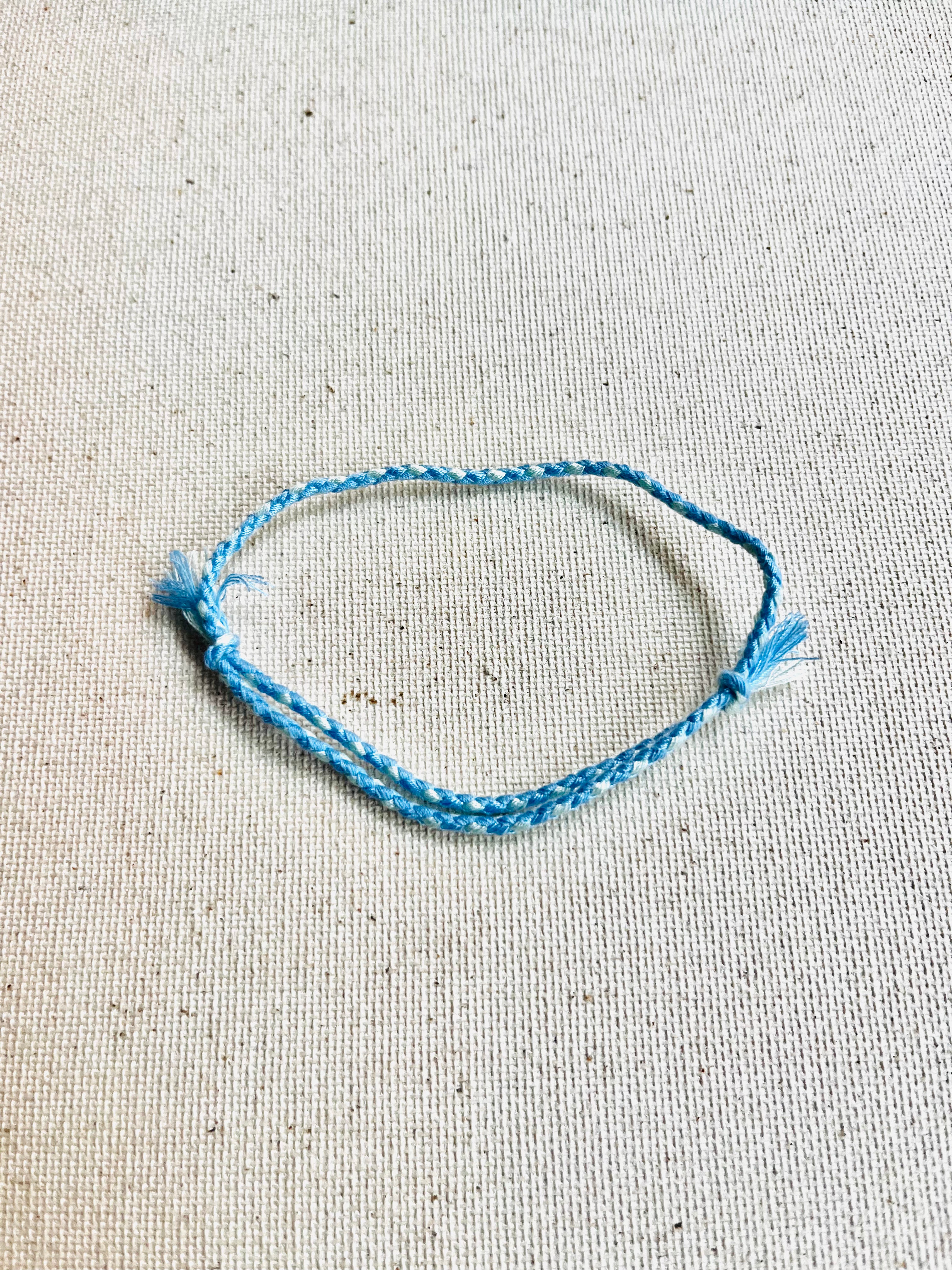 Blue bracelet on a textured beige surface