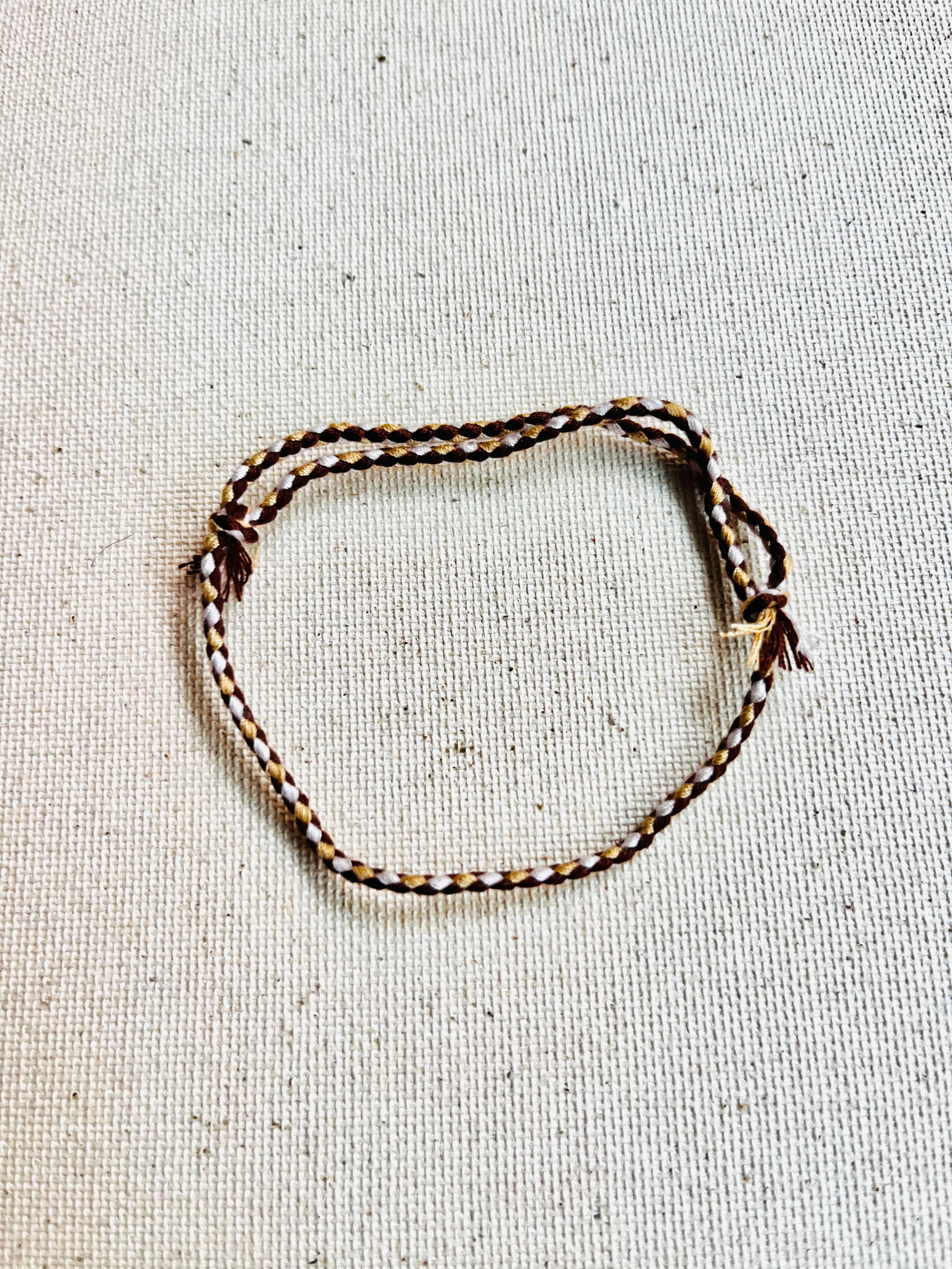 Bracelet with braided design on a textured beige background
