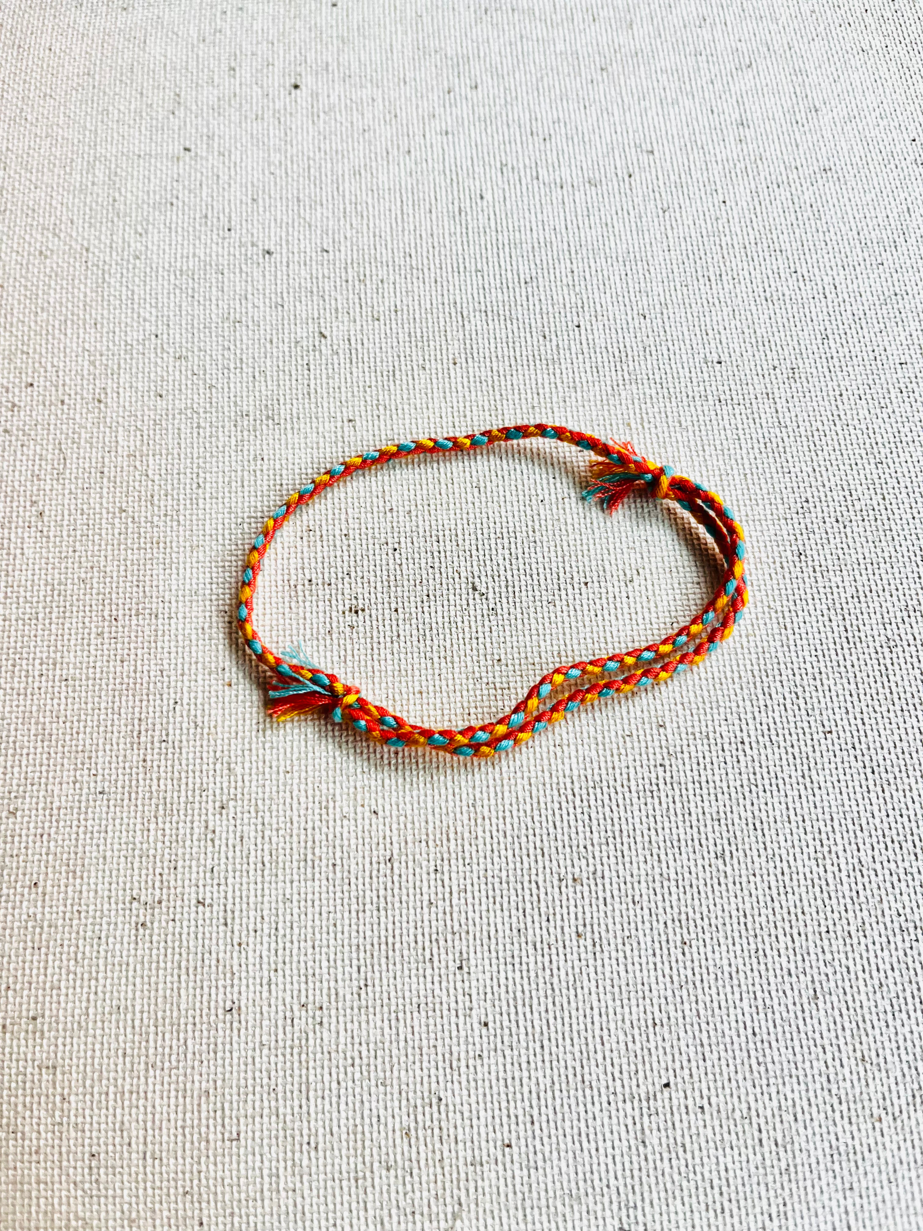Bracelet with braided design on a textured beige background