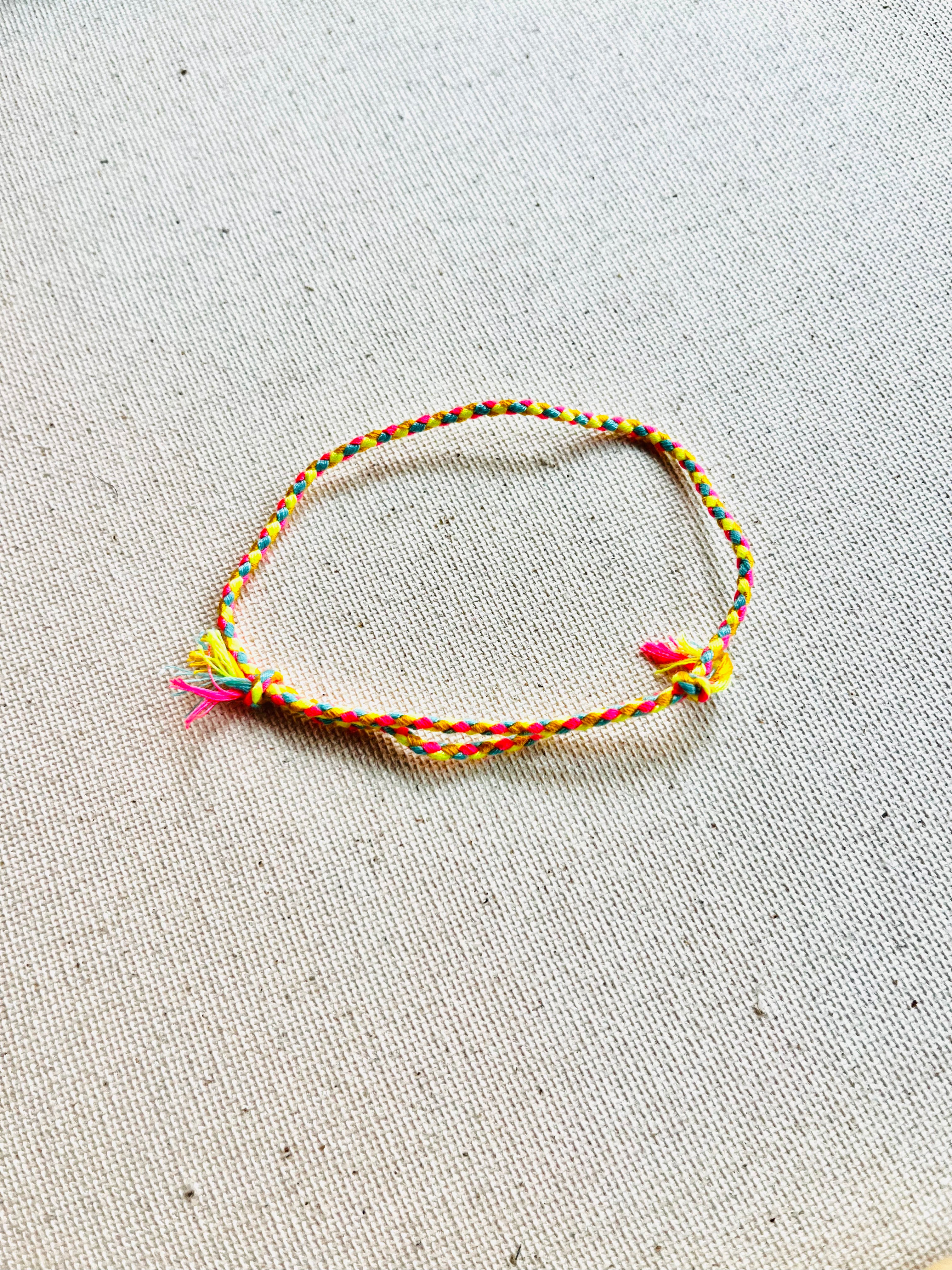 Colorful braided bracelet on a textured beige surface