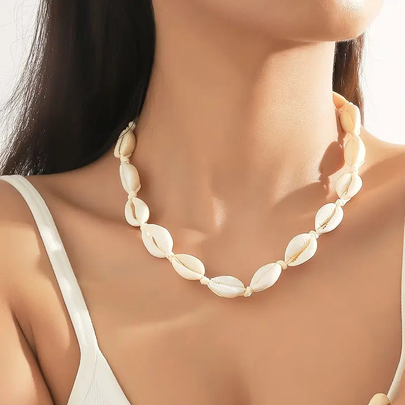 Shell necklace worn by a model with a neutral background