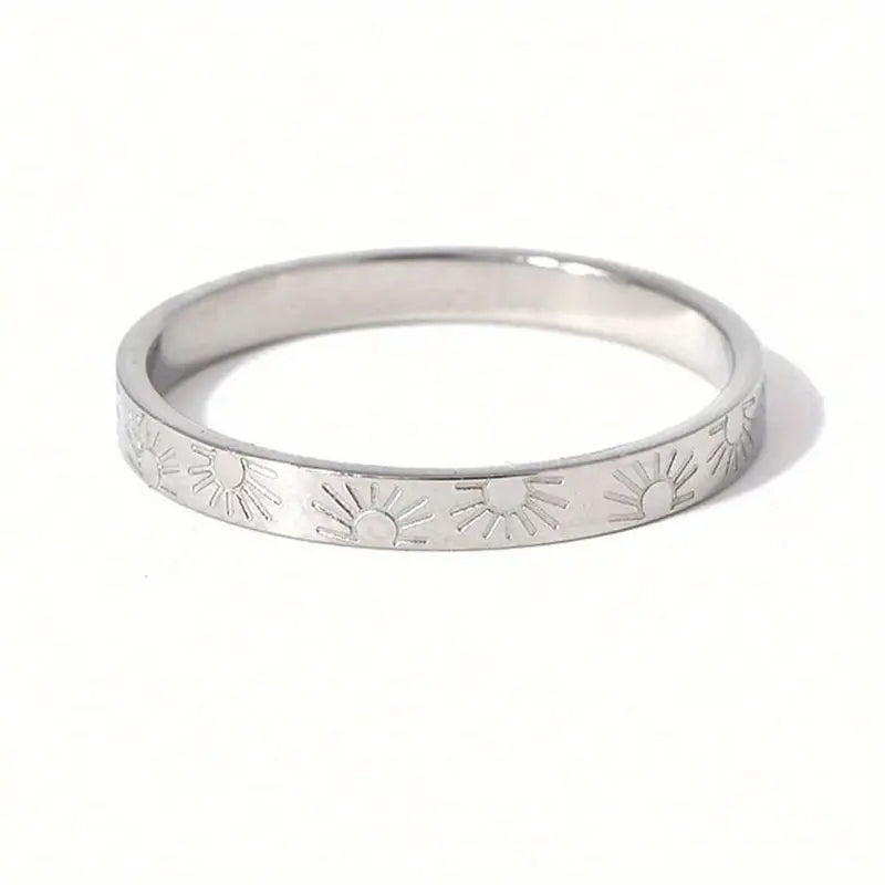 Silver ring with engraved designs on a white background