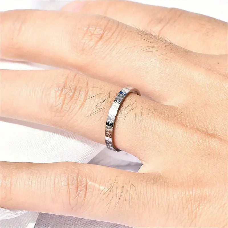 Silver ring on a person's finger with a white background