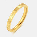 Gold ring with sunburst pattern on a white background